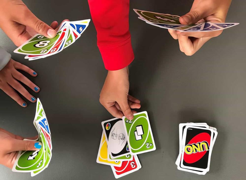 A group of friends are playing an intense game of Uno.